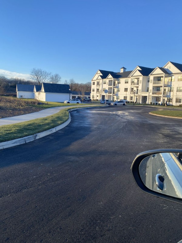 Newly built three-story townhouses are seen at the end of a freshly paved road.