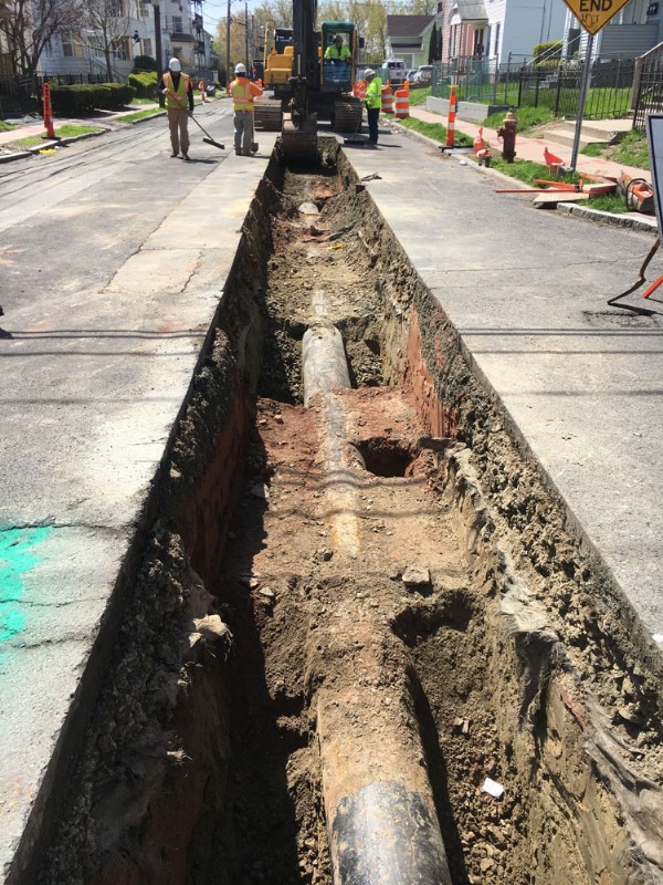 A neat trench opened in the ground to allow crews to repair water and sewer lines.