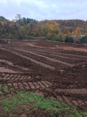 A construction site with piles of dirt in the background. 