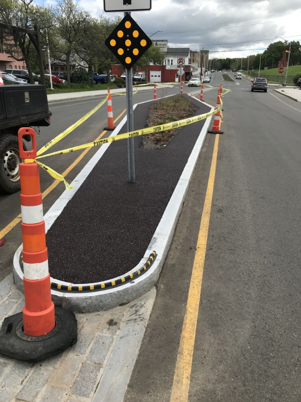 A newly installed median utilizing asphalt and concrete curbing.