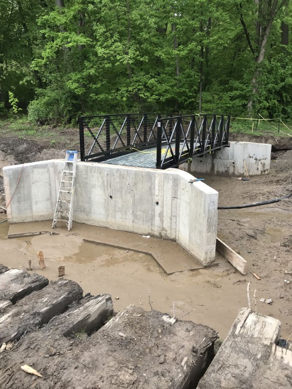 The installation of a new bridge in progress, with a metal structure sitting atop concrete sections.