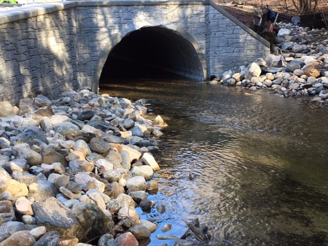 Close-up view of the new arch culvert above Walker Brook, with rock fill on both banks.
