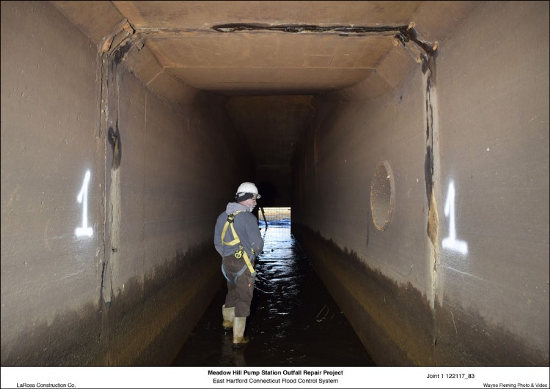 A worker walks in water during construction inside the Meadow Hill Pump Station repair project.