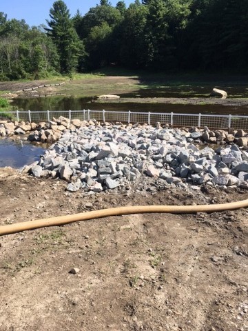 Gravel and rocks piled against a temporary fence at the construction site.