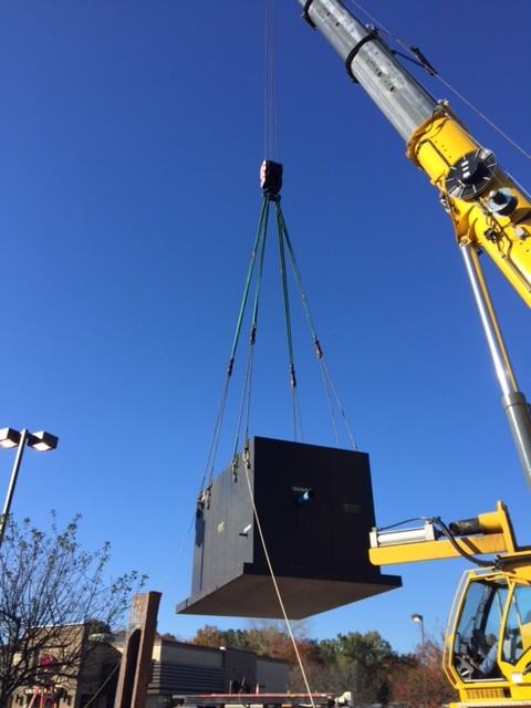 A crane prepares to lower a new enclosure into the ground.