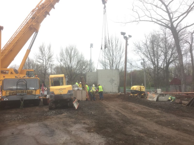 Workers use a crane to place concrete blocks at the construction site.