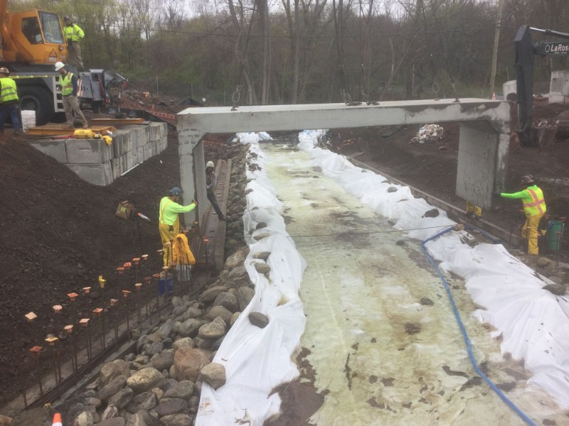 Workers ensure proper alignment of concrete blocks at the construction site.