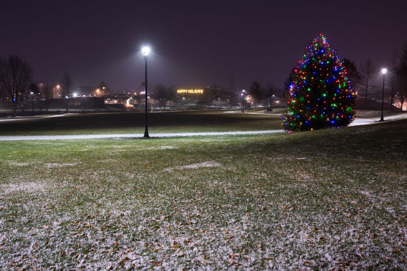 The Meriden Green seen at night after the project completion, with a dusting of snow on the ground and a tree lit up with Christmas lights.