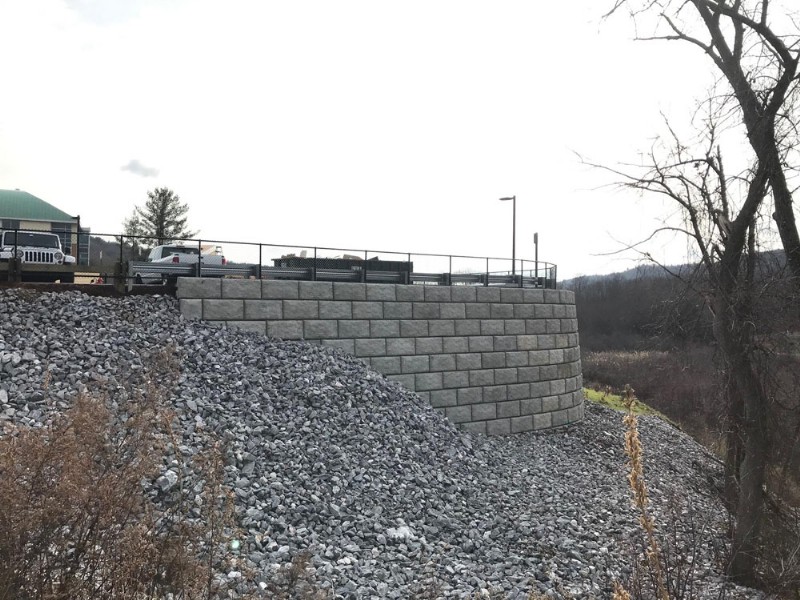 A close-up view of the new retaining wall and gravel fill on the sloped area.