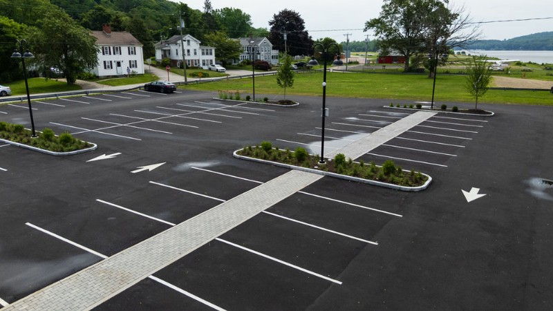Aerial view of the parking lot with the pedestrian walkway and a landscaped area at center.